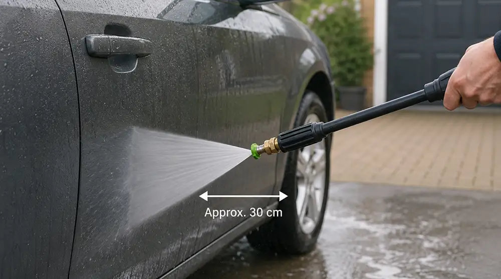 Pressure washer lance around 30 centimetres from car paint using a wide fan spray